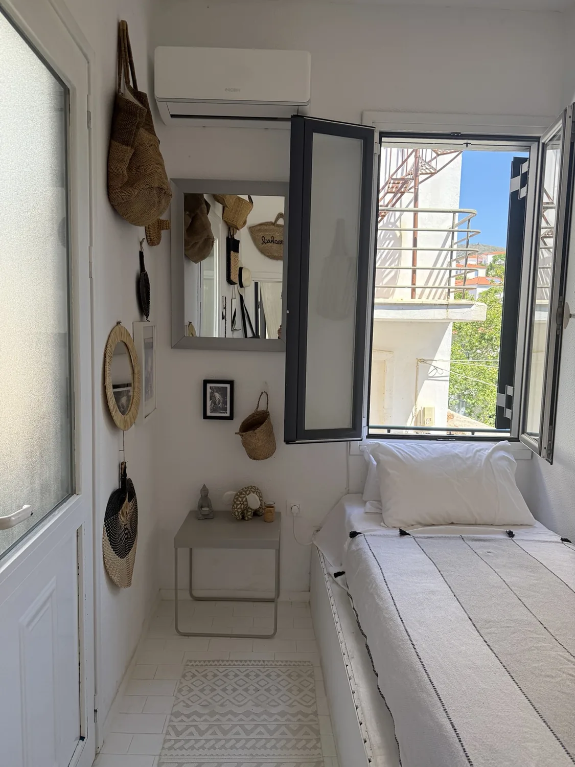 A bedroom with an open window and church view in Batsi